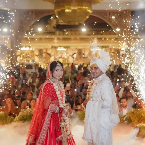 Bride in red and groom with fireworks at a wedding celebration